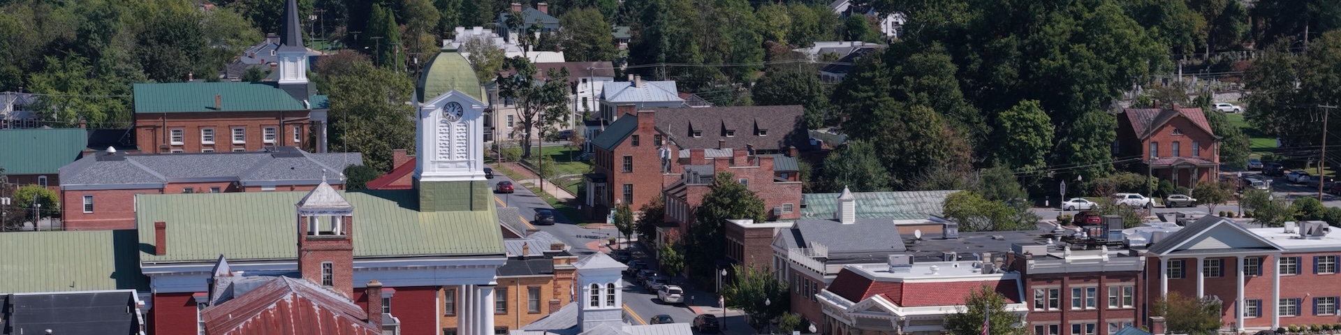 A town with historic buildings, a prominent clock tower, and a water tower.