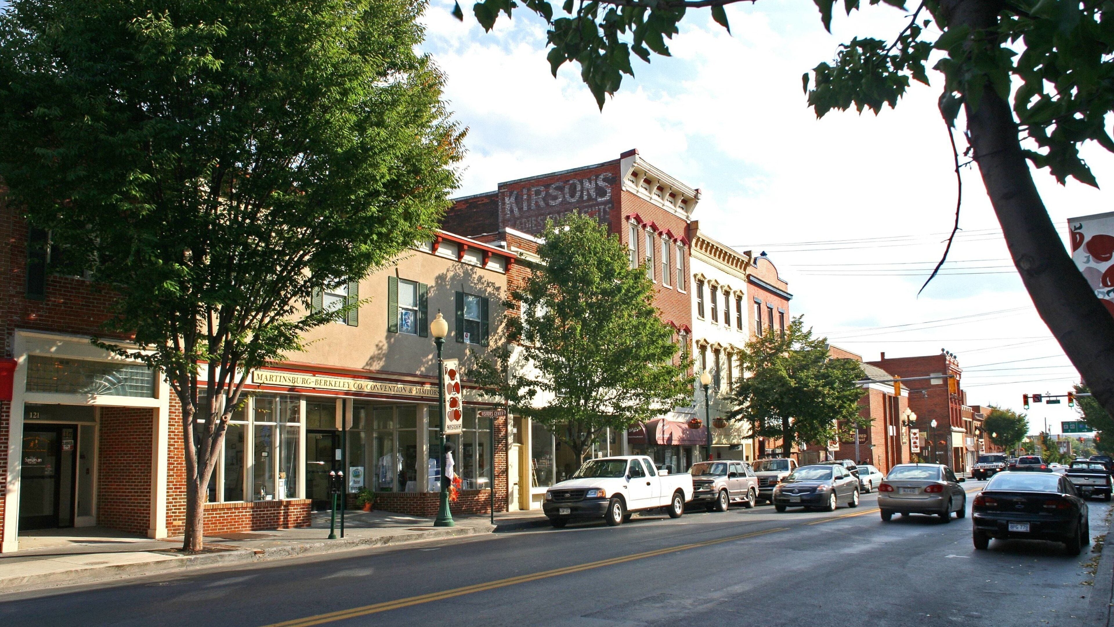 Une rue bordée de bâtiments historiques, dont une enseigne indiquant « KIRSONS » et « MARTINSBURG-BERKELEY CO. CONVENTION & VISITORS ».