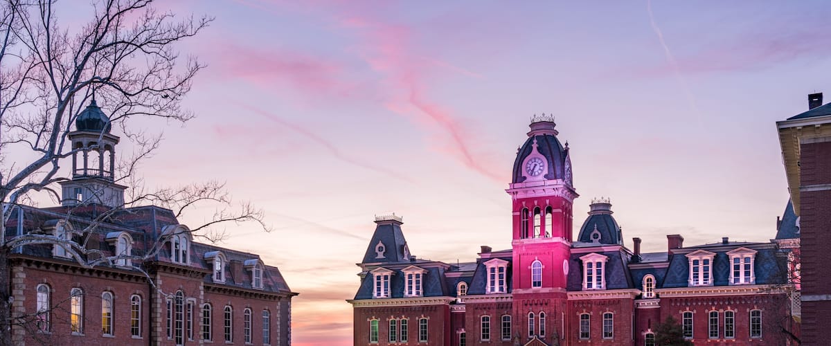 Dramatic image of Woodburn Hall at West Virginia University or WVU in Morgantown WV as the sun sets behind the illuminated historic building