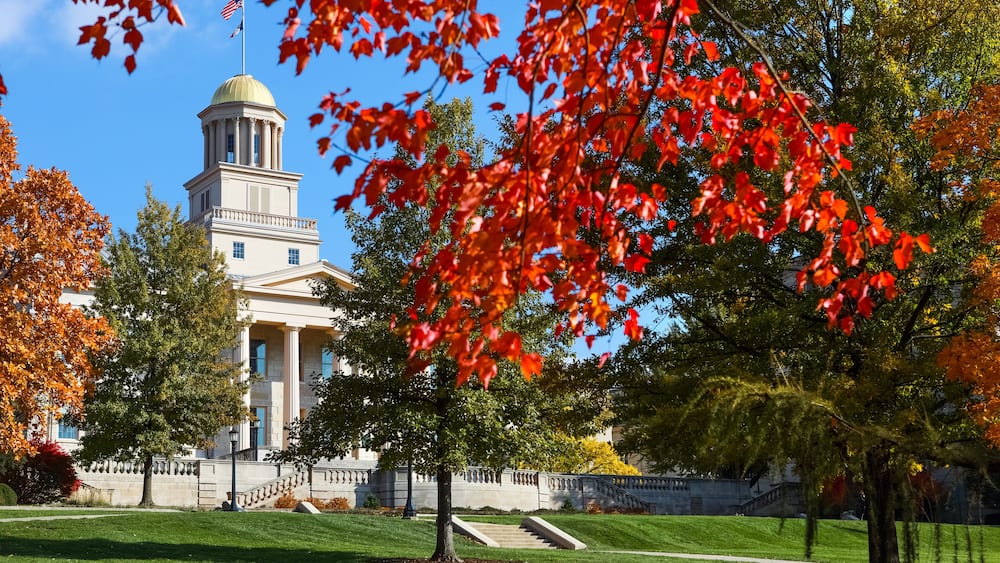 A building with a dome and columns, surrounded by trees with red leaves.
