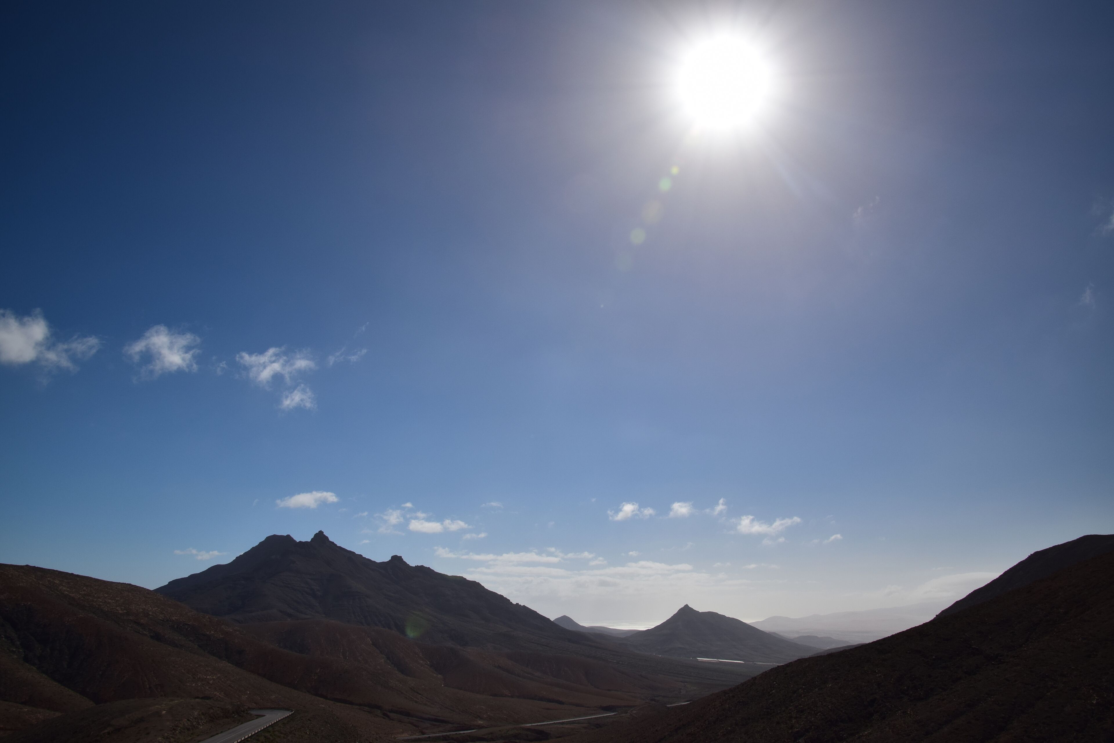A mountainous landscape with a clear sky and a winding road.