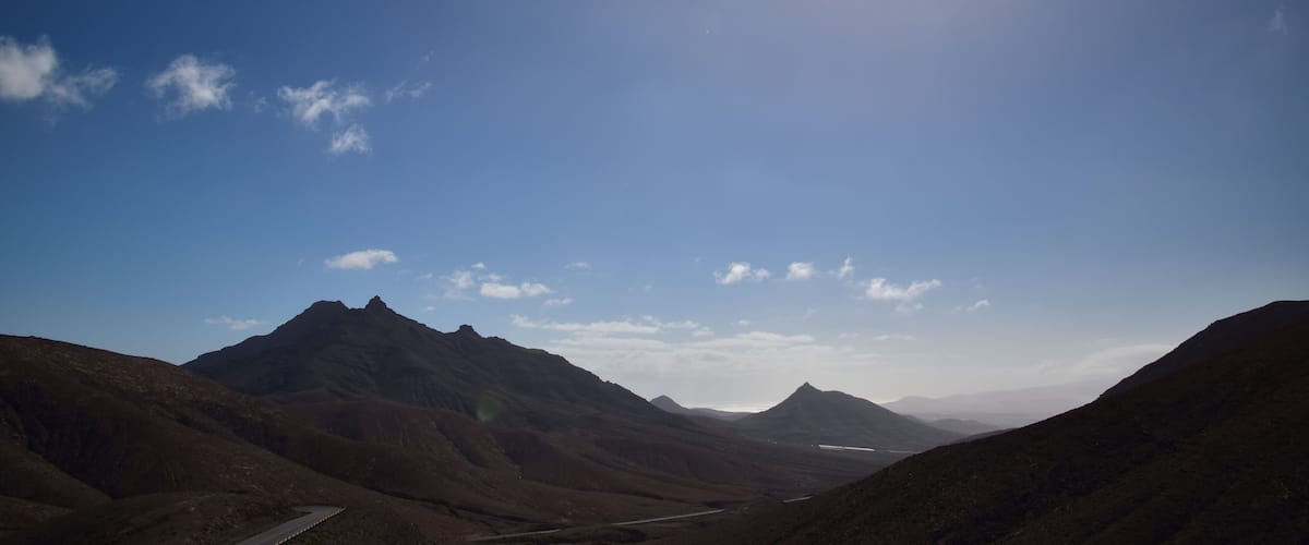 A mountainous landscape with a clear sky and a winding road.
