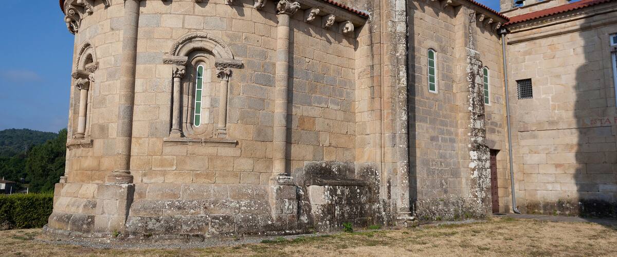 A historic stone building with a bell tower and arched windows.