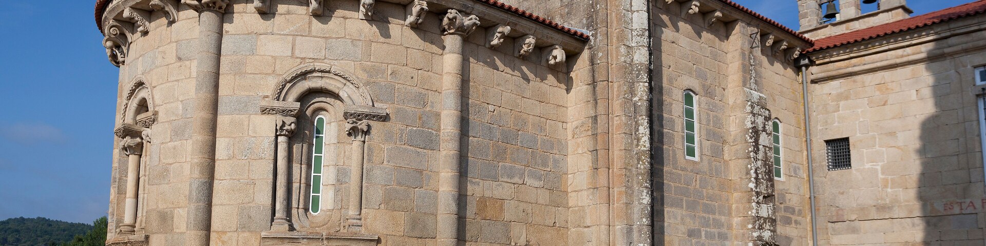 A historic stone building with a bell tower and arched windows.