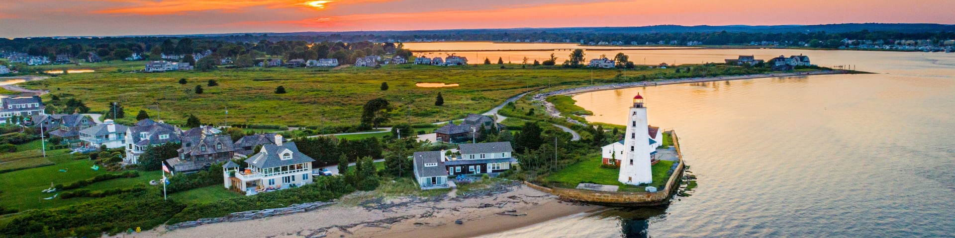 Summer sunset on the Connecticut River, Shoreline, and Long Island Sound in Old Saybrook, CT, with Lynde Lighthouse in the foreground, along with Fenwick, and a colorful summer sunset sky