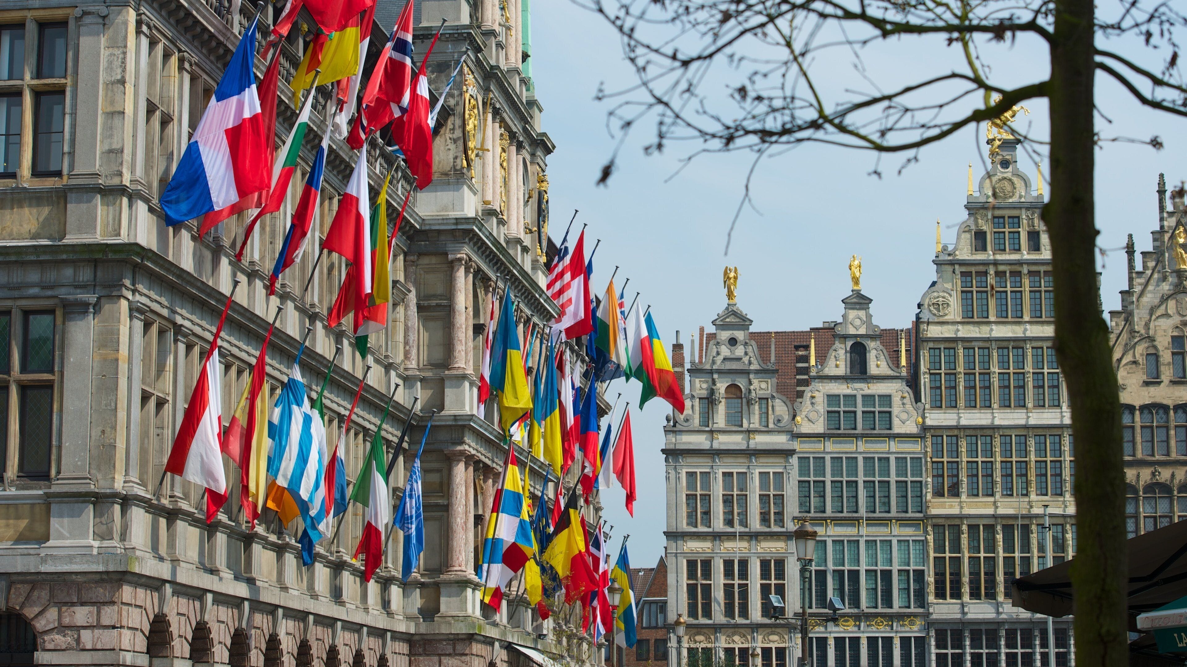 A building with multiple national flags and ornate architecture.