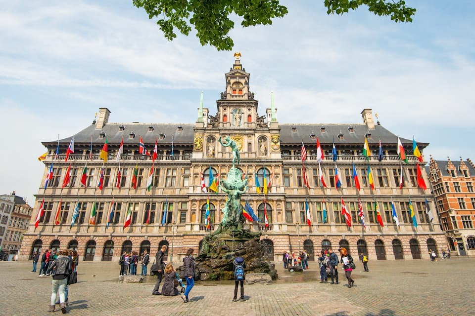 A historic building with a central statue and multiple flags.