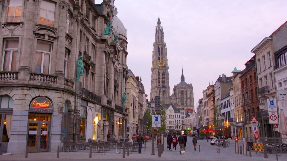 A historic European city square with a prominent cathedral, cafes, and pedestrians.