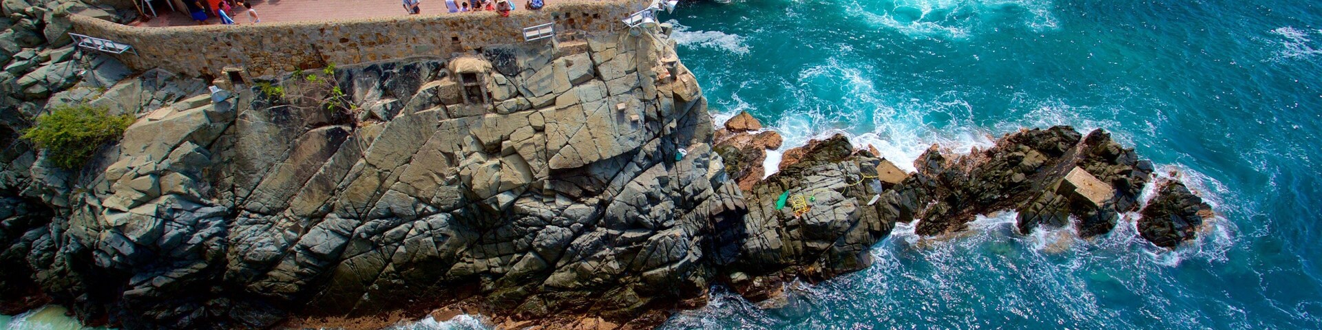 La Quebrada Cliffs featuring rocky coastline as well as a small group of people