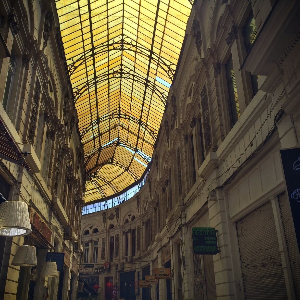 A covered pedestrian mall with ornate architecture and glass ceiling.