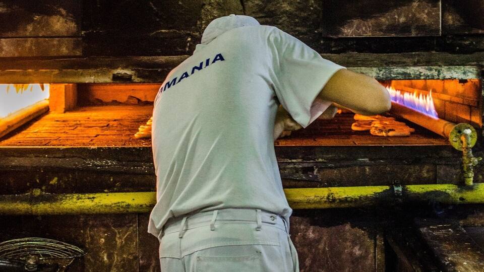 A vendor making soft pretzels at the market. They serve them on a string fresh from the oven. Yummy!!