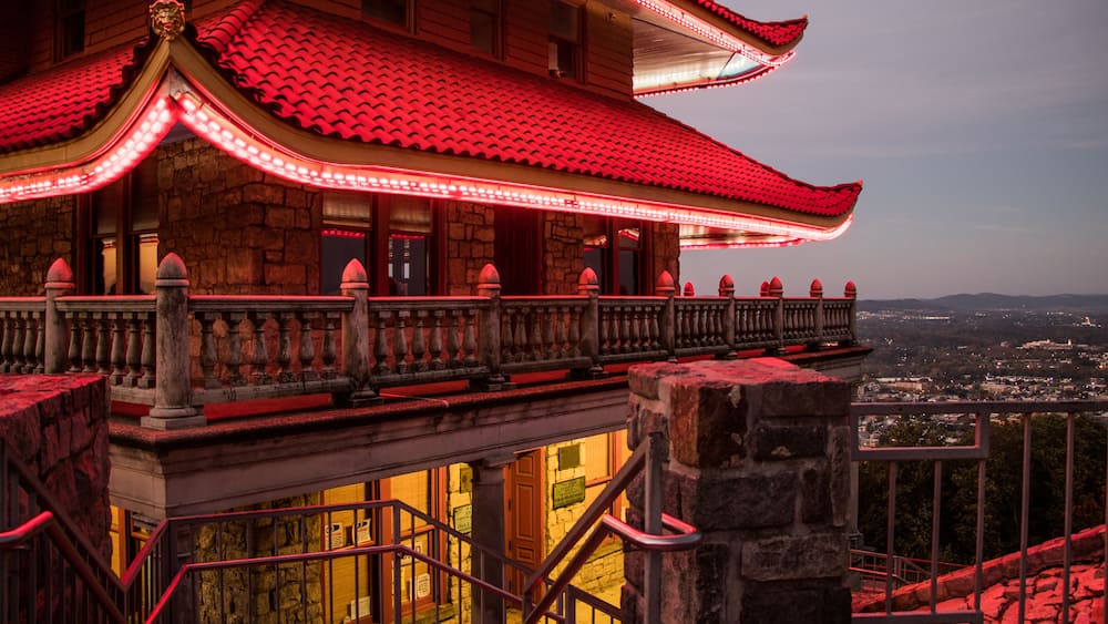 A traditional building with red-tiled roofs and a balcony with railings.