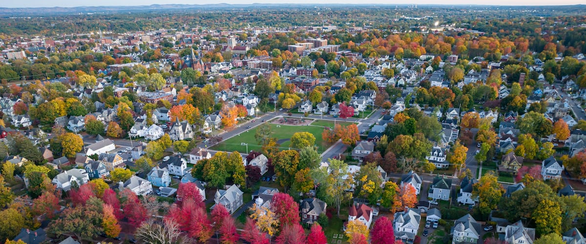 An aerial view of a suburban neighborhood with autumn-colored trees and residential houses.