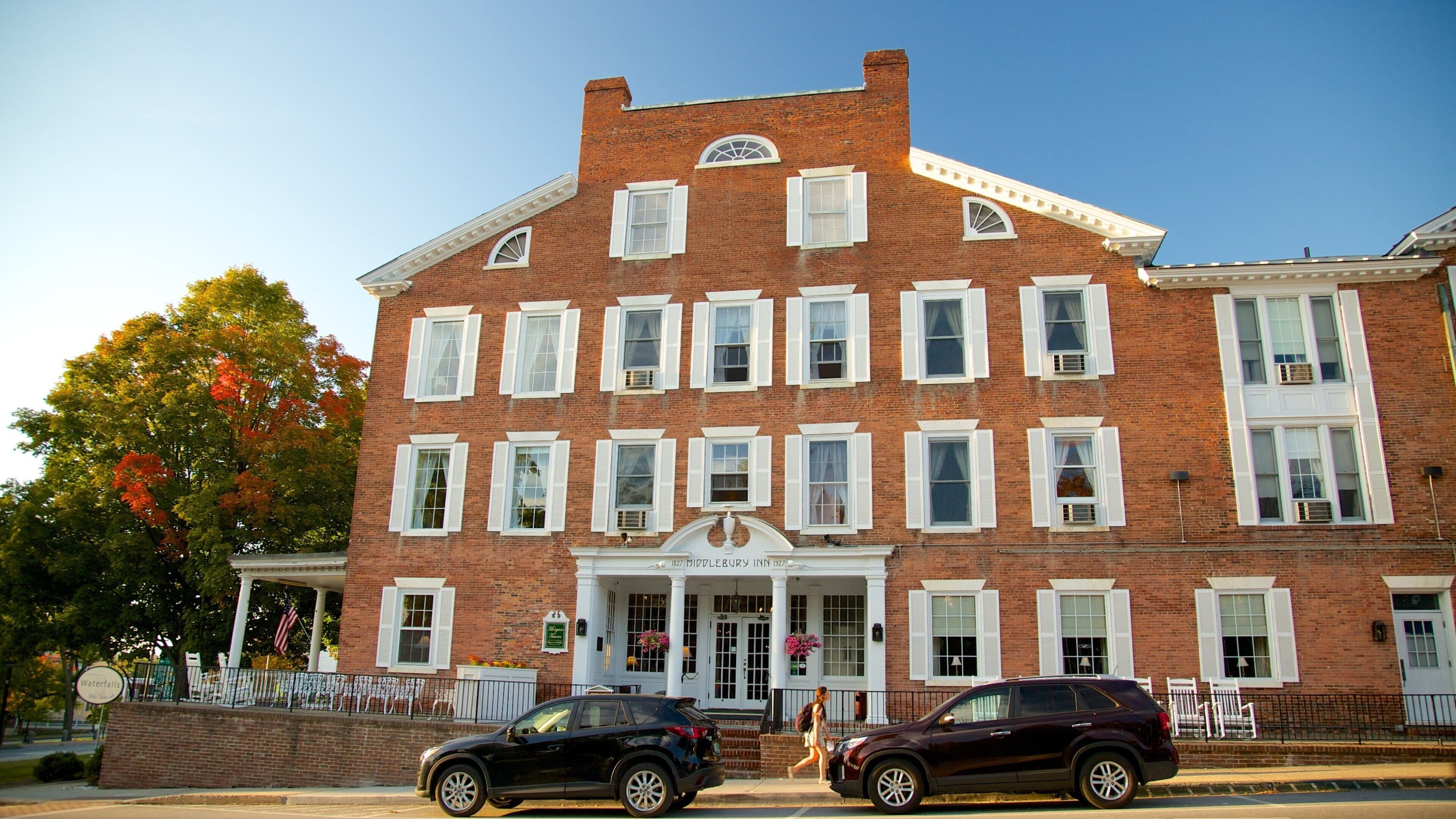 A historic brick building with white shutters and a central entrance.