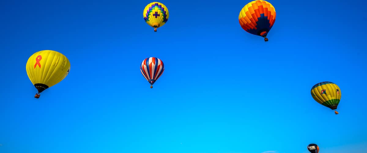 Five hot air balloons in a clear blue sky.