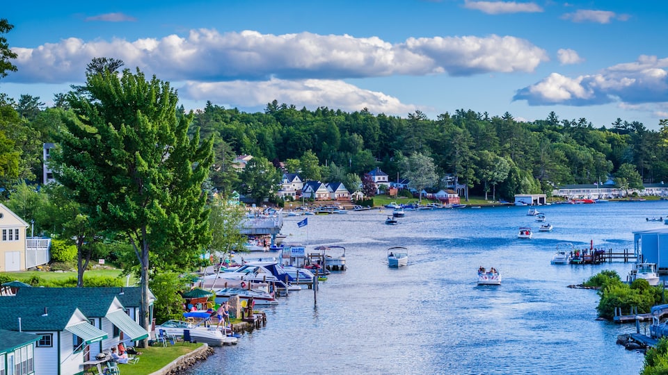A riverside town with boats, houses, and a dock.