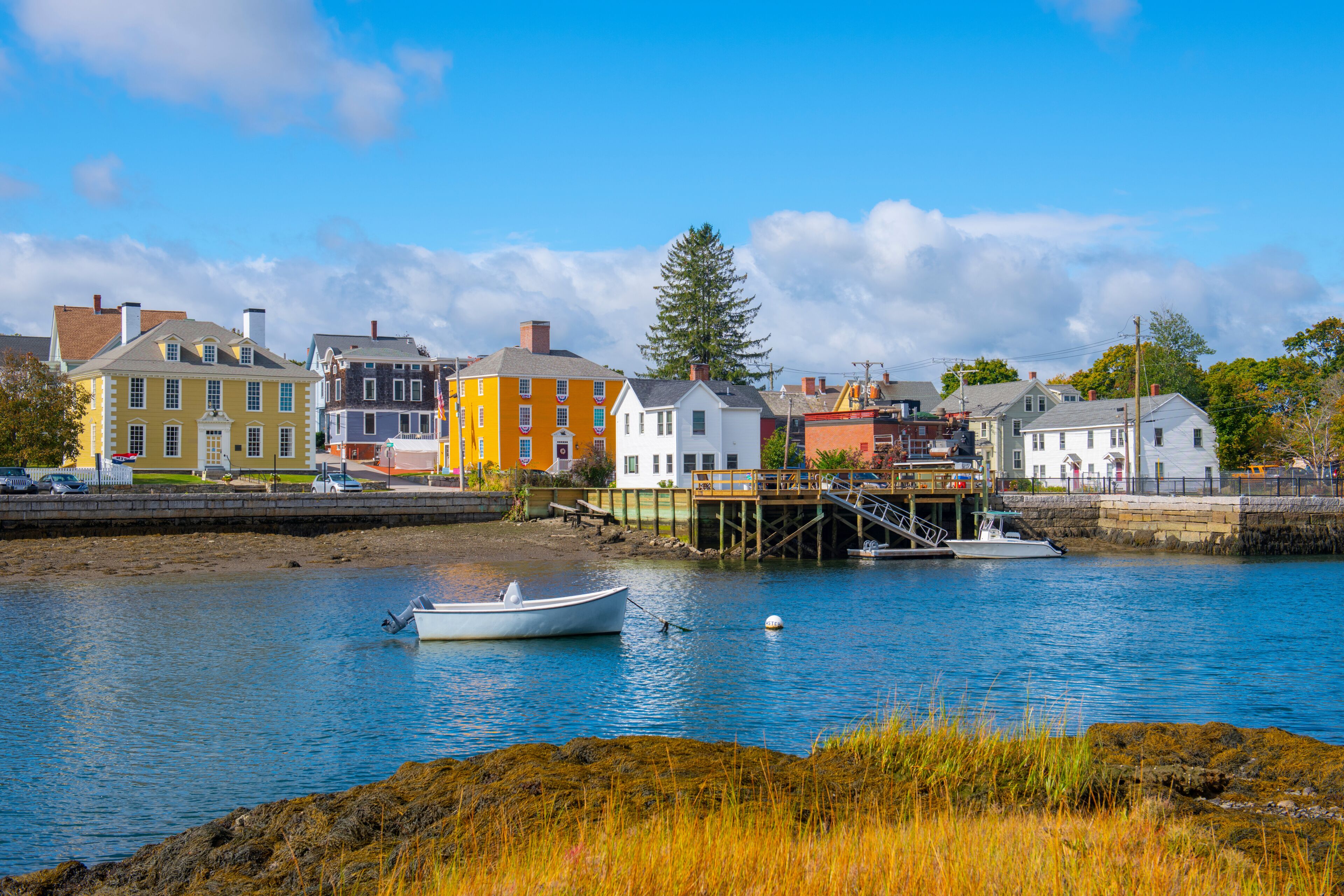 A waterfront town with colorful buildings, a dock, and a small boat.