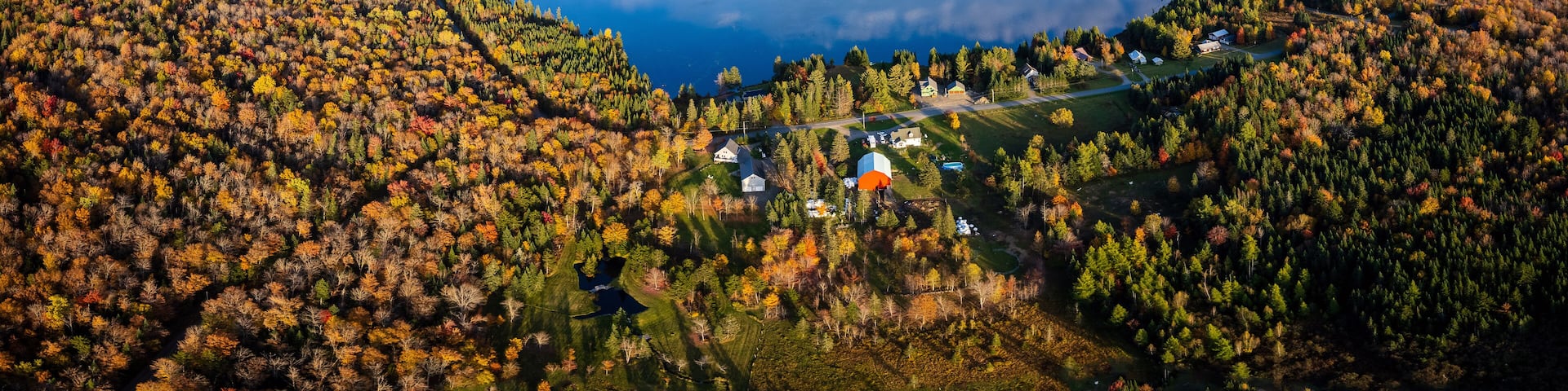 Aerial View of Northern New England Lake With Cloud Reflection Surrounded By Vibrant Fall Foliage - Back Lake in Pittsburg, New Hampshire