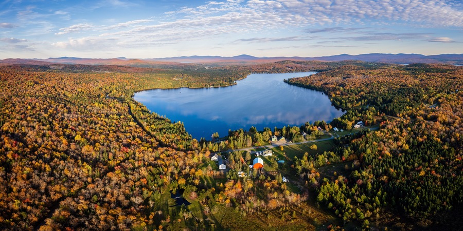 Aerial View of Northern New England Lake With Cloud Reflection Surrounded By Vibrant Fall Foliage - Back Lake in Pittsburg, New Hampshire