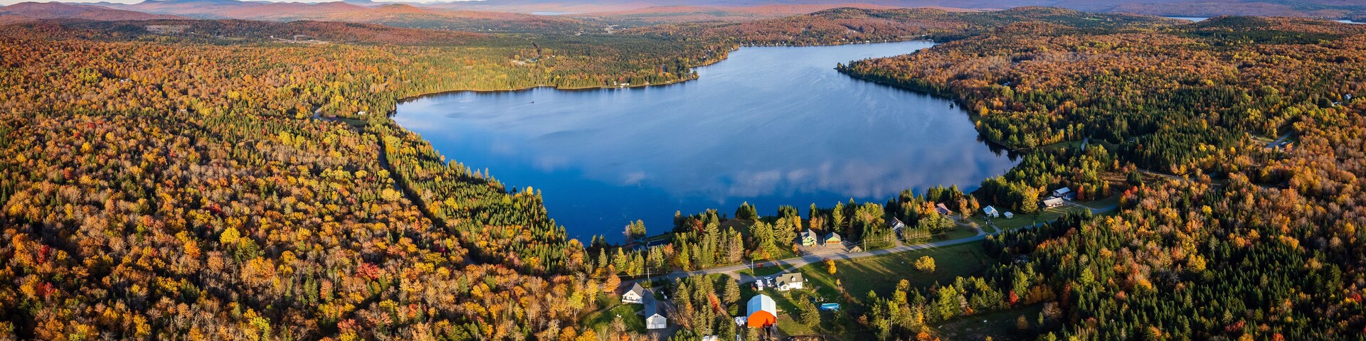Aerial View of Northern New England Lake With Cloud Reflection Surrounded By Vibrant Fall Foliage - Back Lake in Pittsburg, New Hampshire