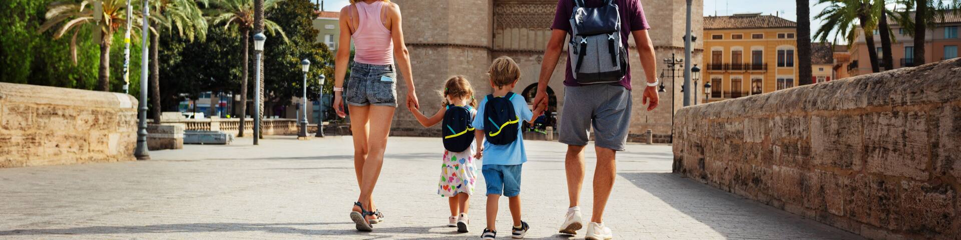 Parents with kids walk in front of famous Torres de Serrans