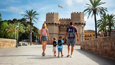 Parents with kids walk in front of famous Torres de Serrans