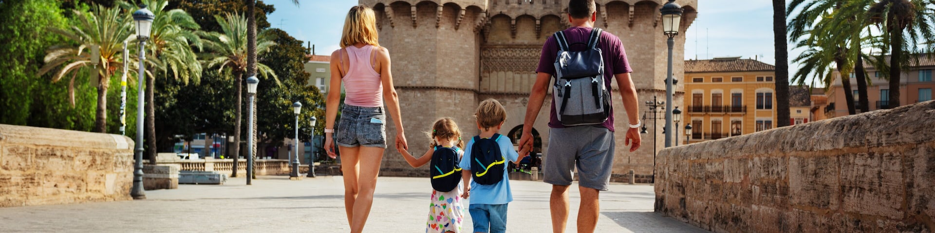 Parents with kids walk in front of famous Torres de Serrans