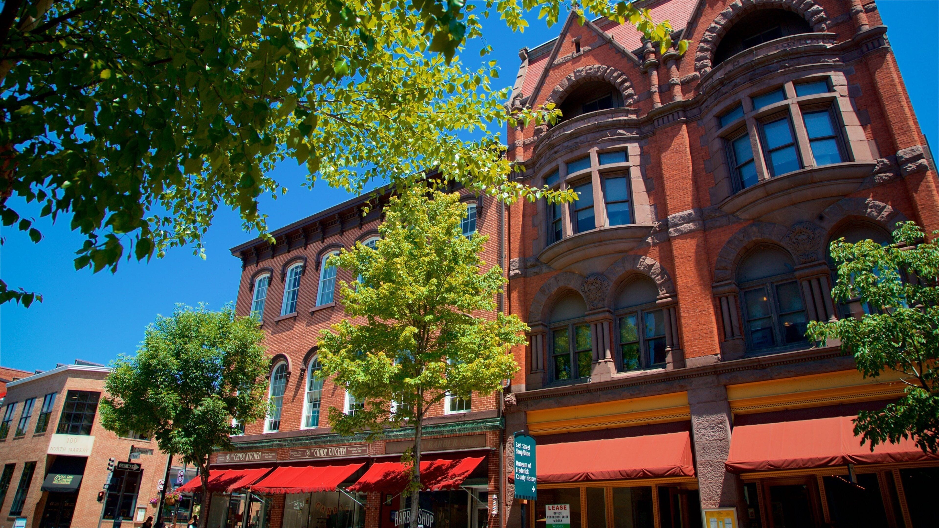 A historic red brick building with arched windows and a red awning.
