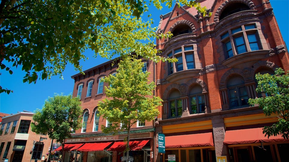 A historic red brick building with arched windows and a red awning.