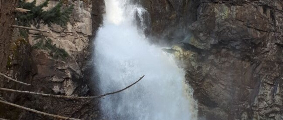 Uma cascata descendo por um penhasco rochoso.