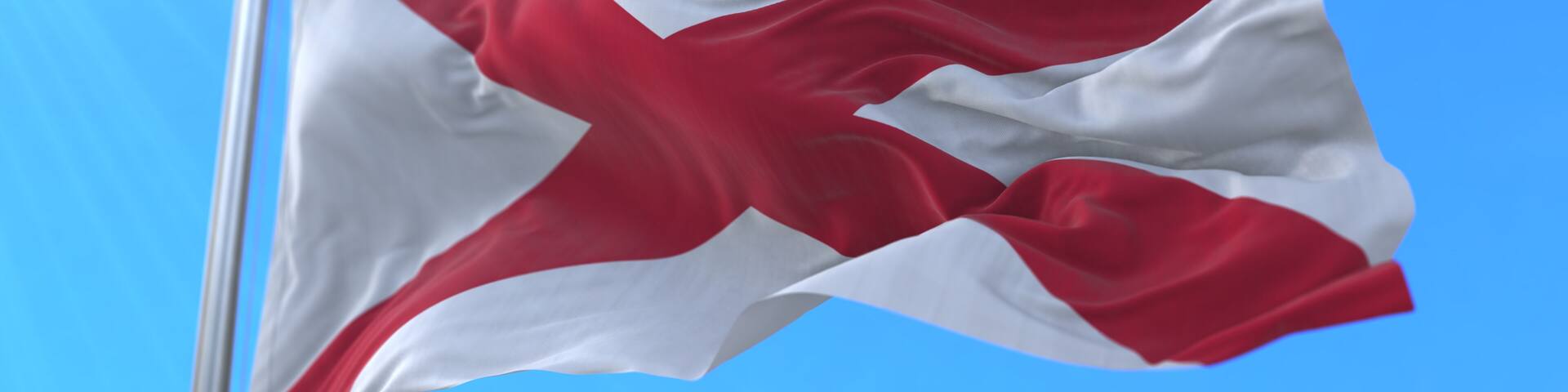 Flag of Alabama state, region of the United States, waving at wind