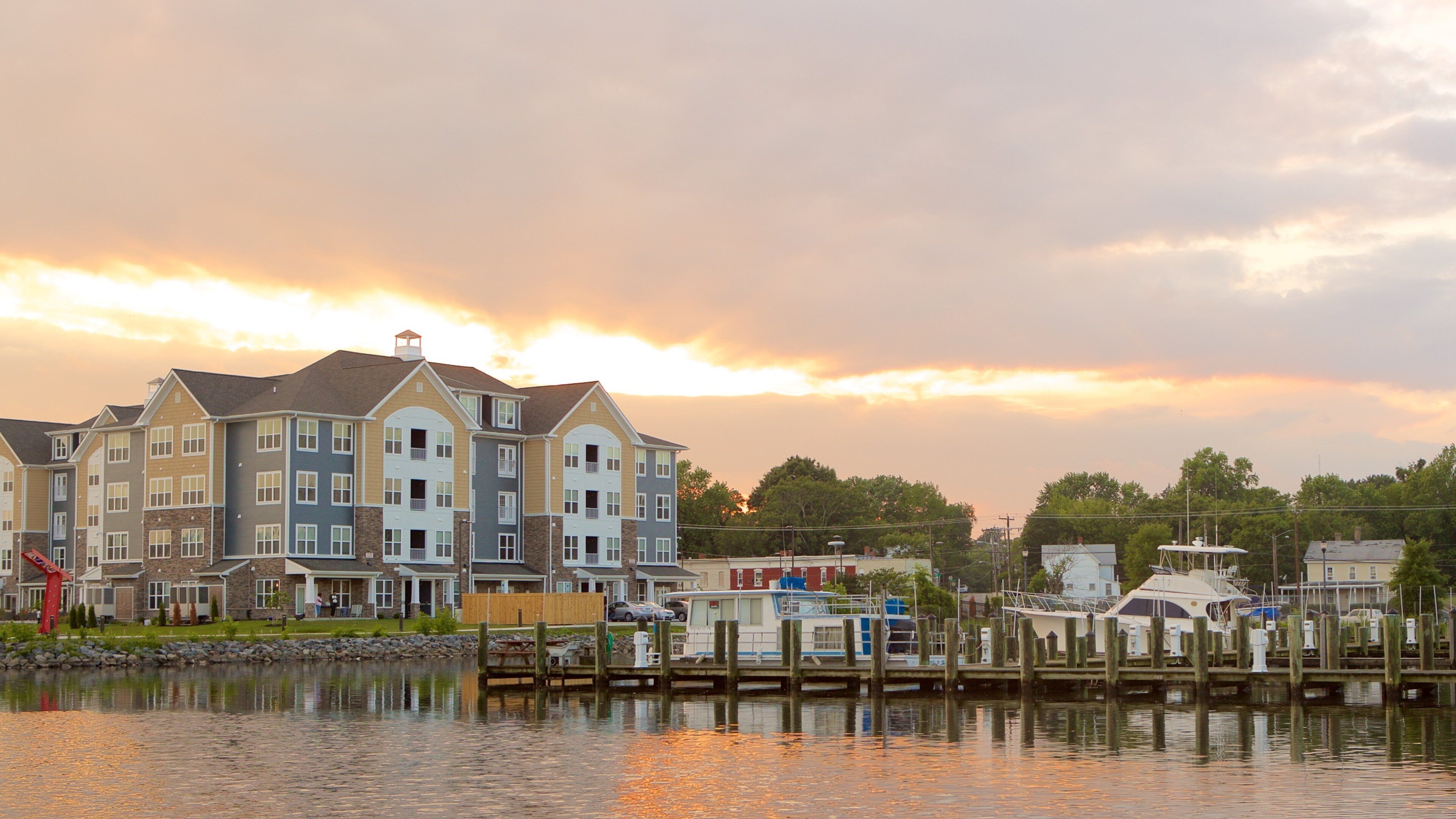 A waterfront residential area with multi-story buildings and docked boats.