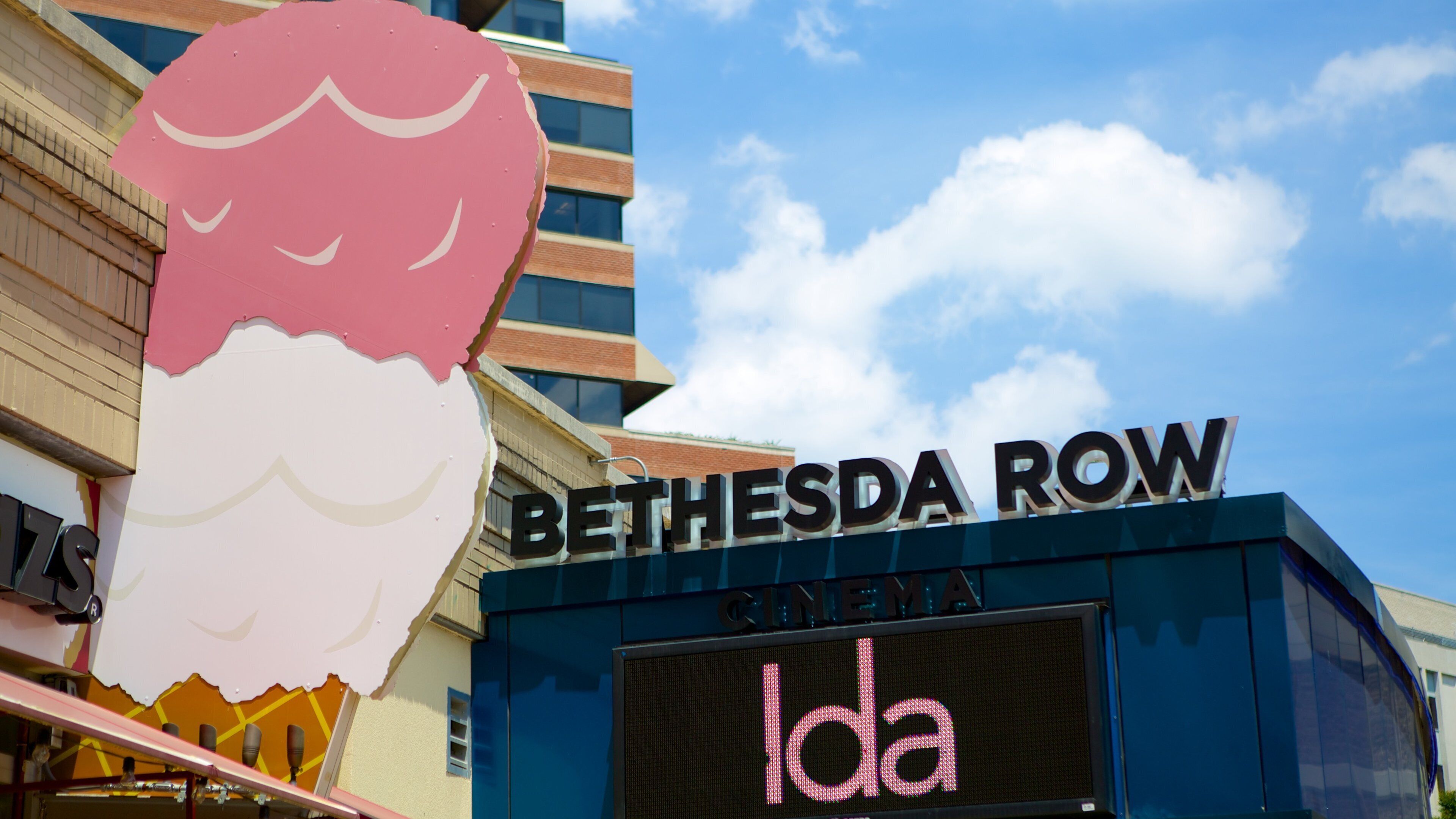 A sign for Bethesda Row with a cinema and a digital display.