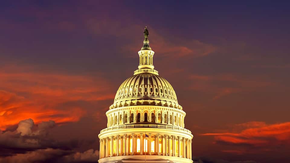 The United States Capitol building at sunset with a dramatic sky.