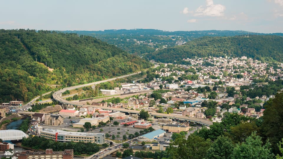 A town nestled in a valley with a river running through it, surrounded by hills.