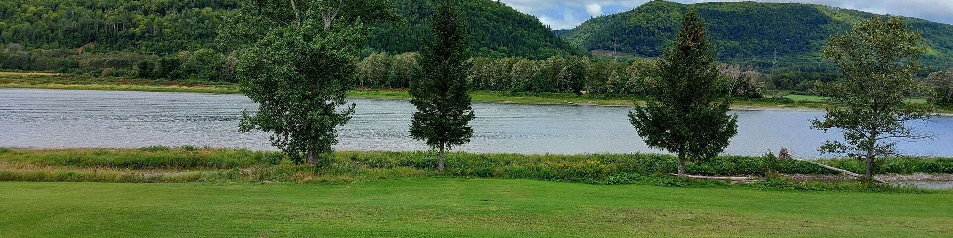 Un lago rodeado de abundante vegetación y colinas.