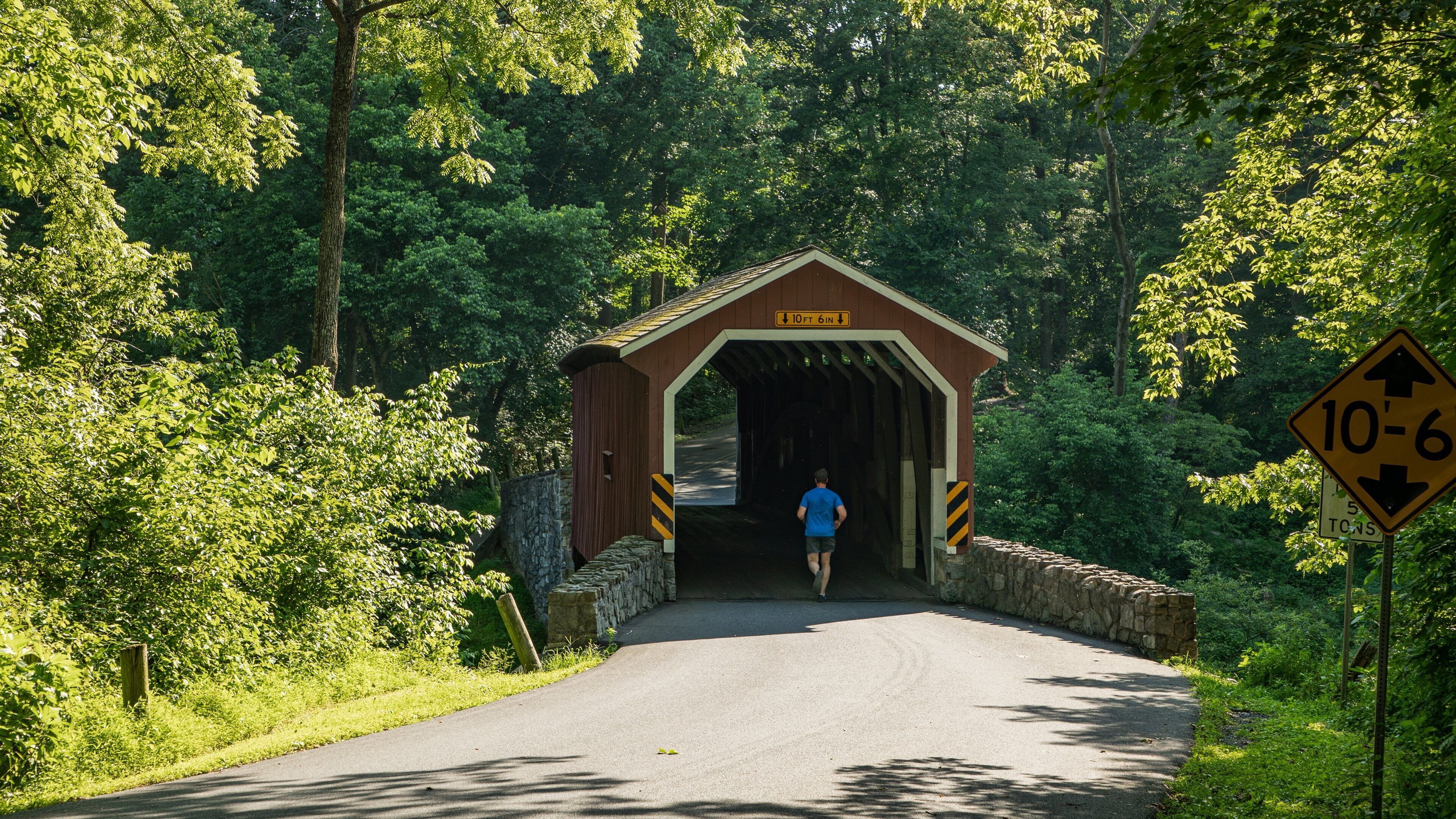 A covered bridge with a sign indicating a height limit of 10 feet 6 inches.