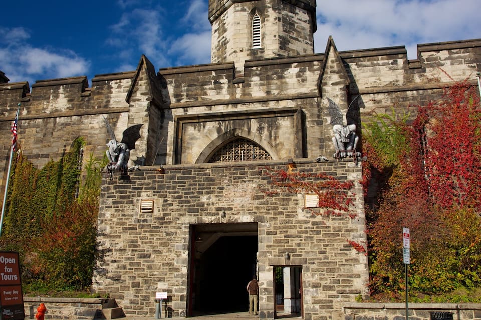 A historic stone building with a tower, arched windows, and statues.