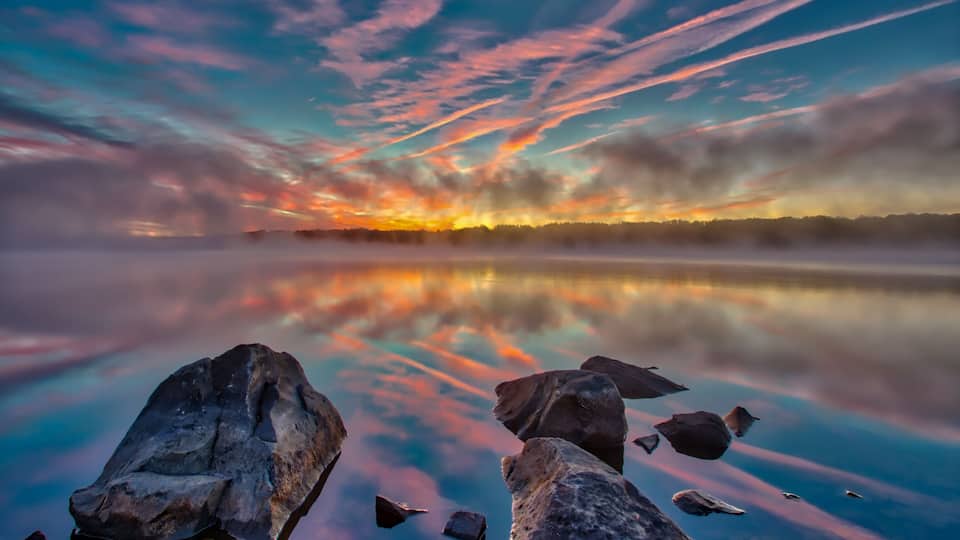 Foggy pre-sunrise skies over the lake in Nockamixon State Park located in Bucks County Pennsylvania.