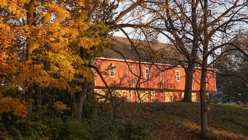 A red building surrounded by autumn foliage.