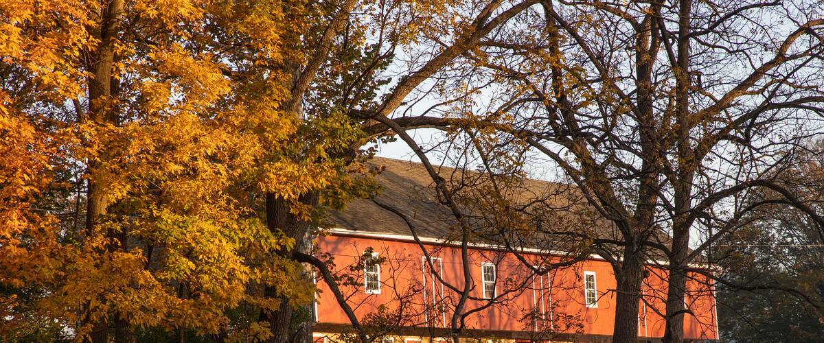 A red building surrounded by autumn foliage.