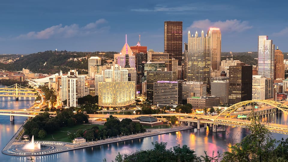 A cityscape with a river, bridges, and high-rise buildings.