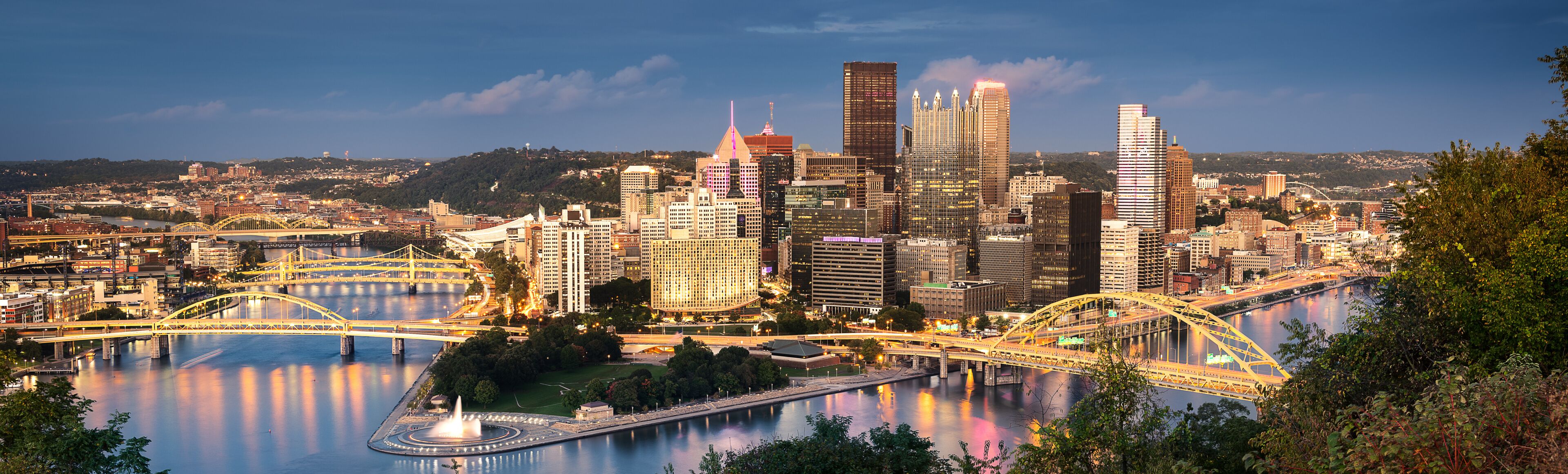 A cityscape with a river, bridges, and high-rise buildings.