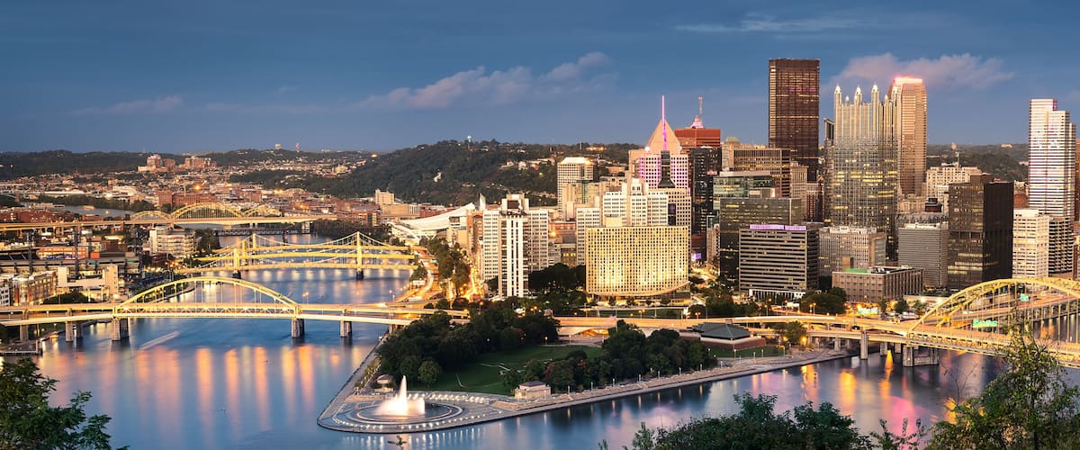 A cityscape with a river, bridges, and high-rise buildings.