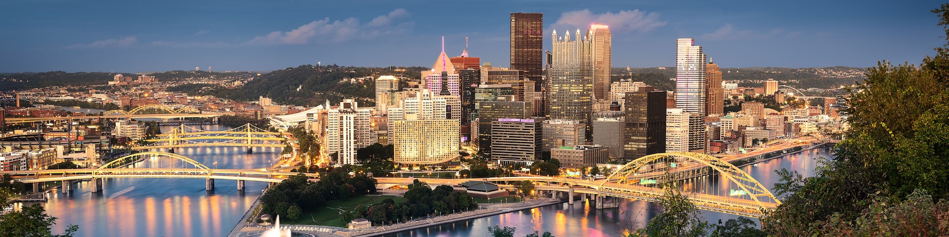 A cityscape with a river, bridges, and high-rise buildings.