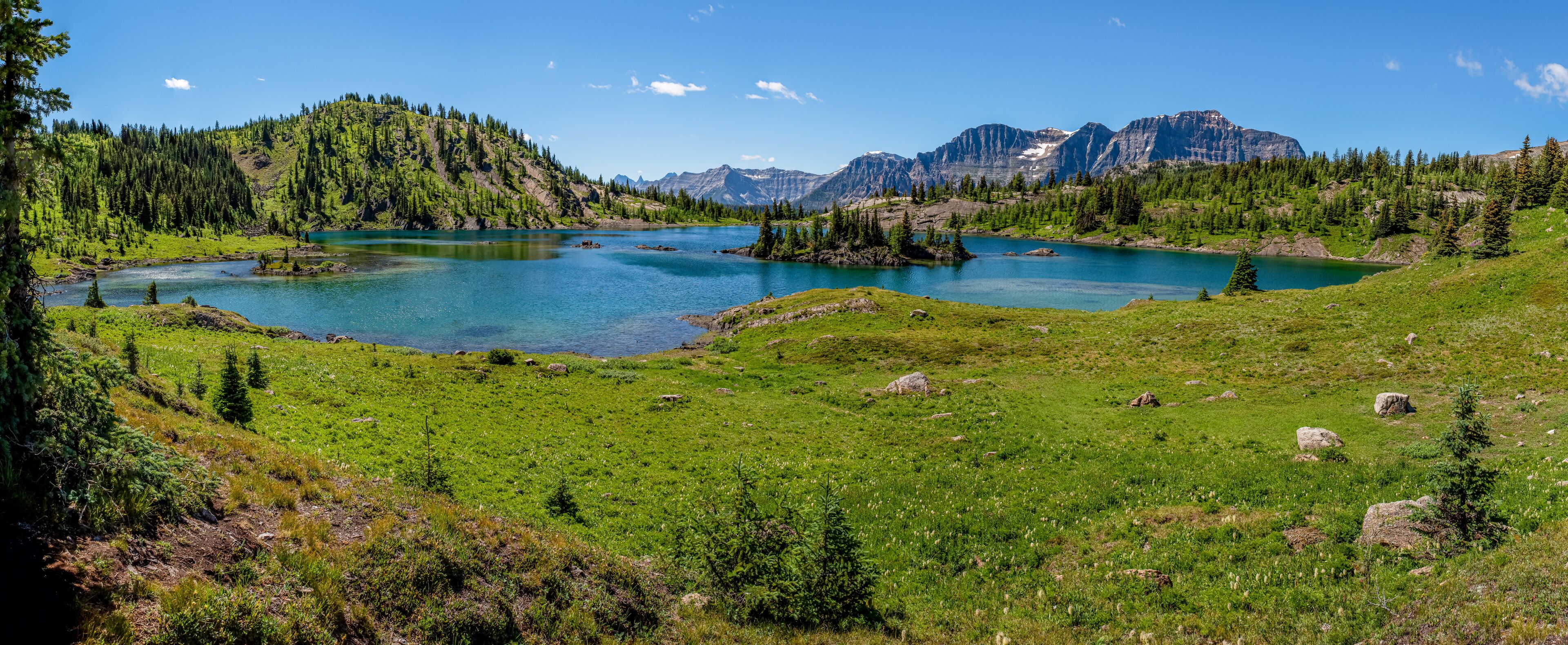 A mountain lake surrounded by forested hills and mountains.