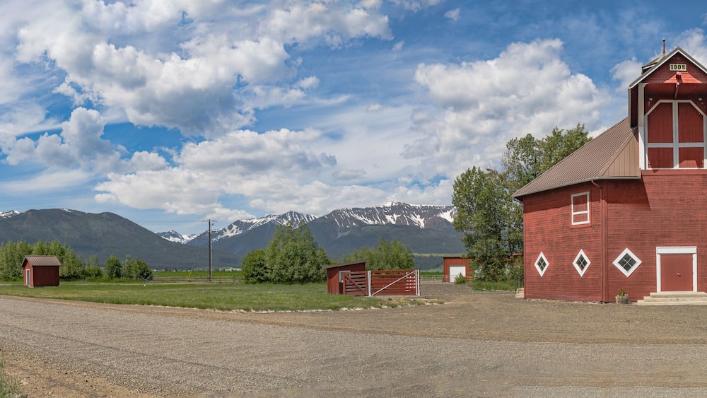 Iconic wooden red barn in Eastern Oregon with the Cascade Mountains in the background