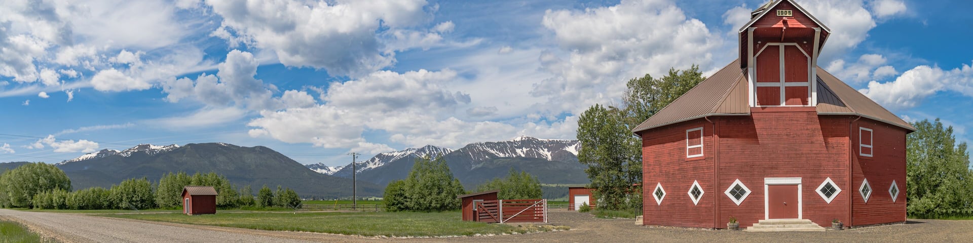 Iconic wooden red barn in Eastern Oregon with the Cascade Mountains in the background