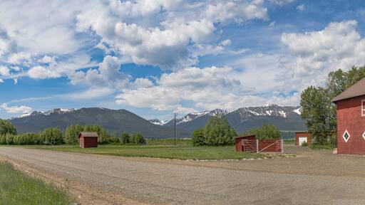 Iconic wooden red barn in Eastern Oregon with the Cascade Mountains in the background