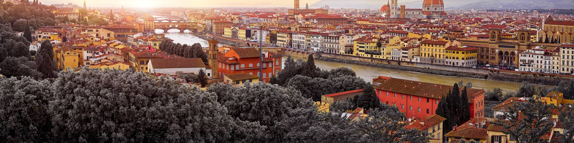 Florence (Firenze, Italy. Sunset panorama. Evening view at ancient city. Famous Ponte Vecchio bridge on river Arno scenic clouds and sky. Duomo Santa Maria del Fiore cathedral, Palazzo Tower
